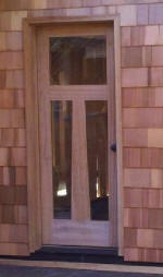 Unique mahogany wood door features irregular shape in panel
